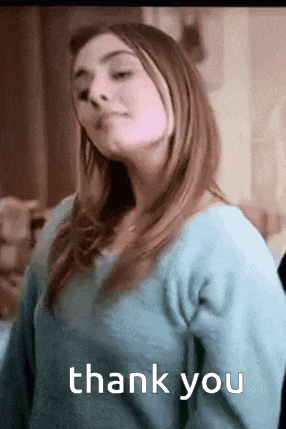 a woman in a blue sweater is giving a thank you .