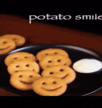 a plate of potatoes with smiley faces on them and a side of dipping sauce