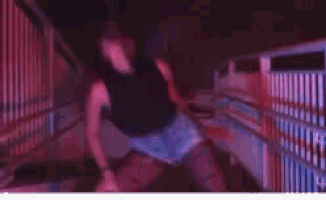 a woman in shorts is dancing in a room with a red light behind her .