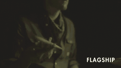 a man in a green shirt is playing drums and the word flagship is visible in the corner