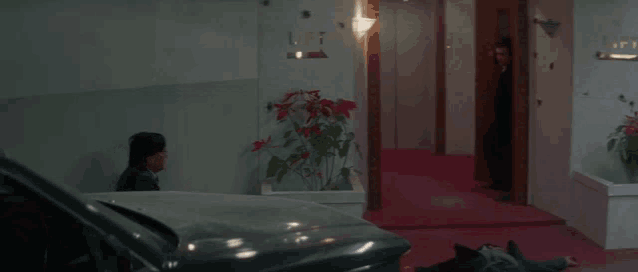 a man is standing in a hallway with bullet holes in the walls