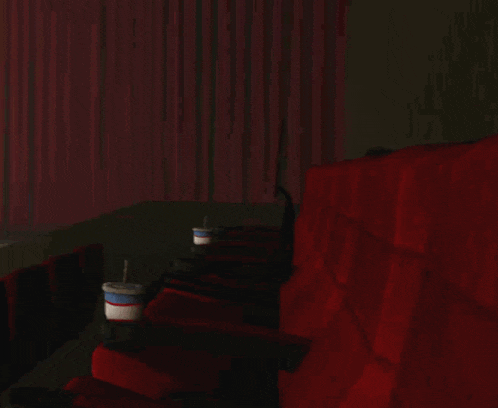 a troll face is sitting in a theater seat