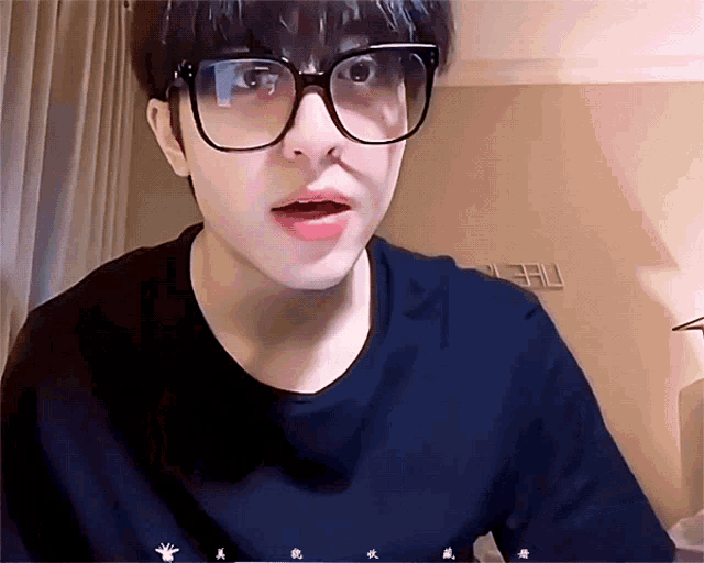 a close up of a person wearing glasses and a shirt that says ' eau ' on it