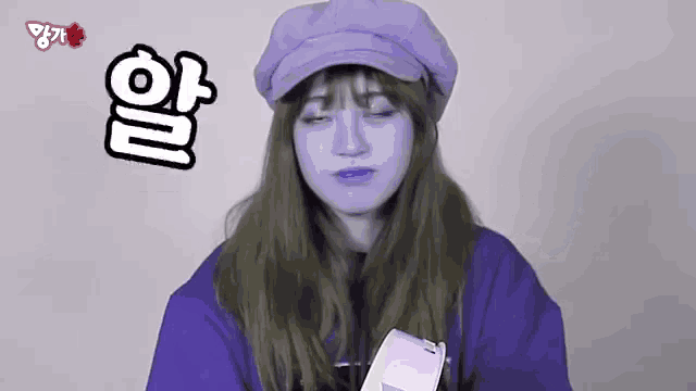 a woman wearing a purple hat and a purple shirt is making a face .