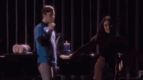 a man and a woman are dancing on a stage .
