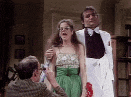 a woman in a green dress and a man in a white tuxedo are standing next to each other