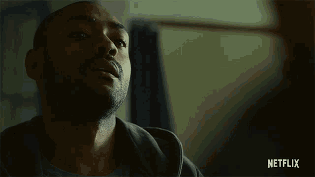 a man in a dark room with a netflix logo on the bottom