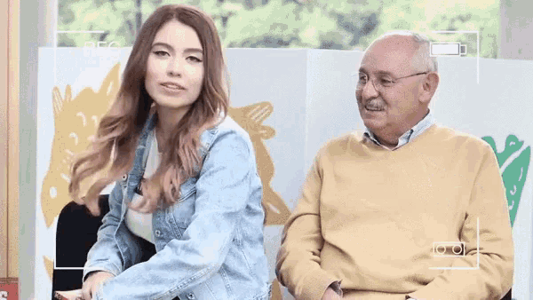a man and a woman are sitting next to each other and the woman is wearing a watch