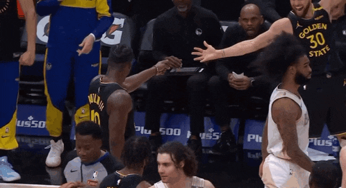 a basketball player in a golden state warriors jersey shakes hands with another player