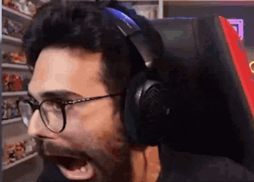 a man wearing glasses and headphones is sitting in a chair .