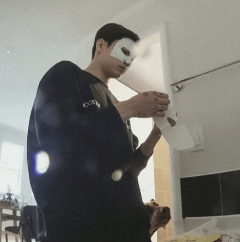 a man with a bandage on his face is wearing a black sweatshirt with the word 100 on the sleeve