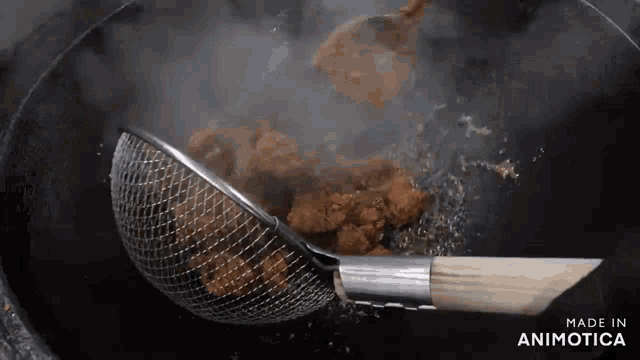 a strainer with a wooden handle is being used to strain food from a pot