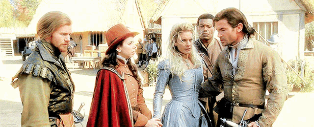 a group of people are standing next to each other and one of them is wearing a hat