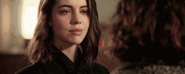 a close up of a woman looking at another woman with a sad look on her face .