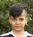 a young boy with a shaved head is wearing a black and white striped shirt .