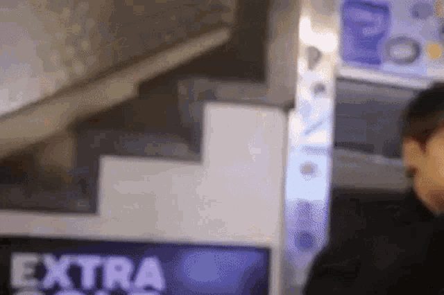 a man is standing in front of a sign that says extra on it .