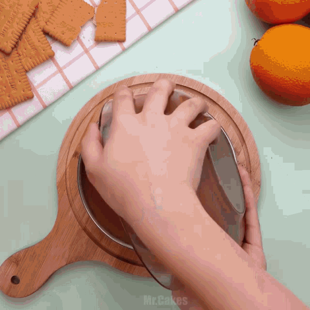 a wooden cutting board with a person 's hand on it that says mrcakes on the bottom