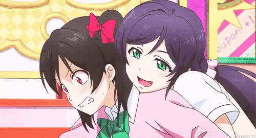 two anime girls are hugging each other and one has a red bow in her hair .