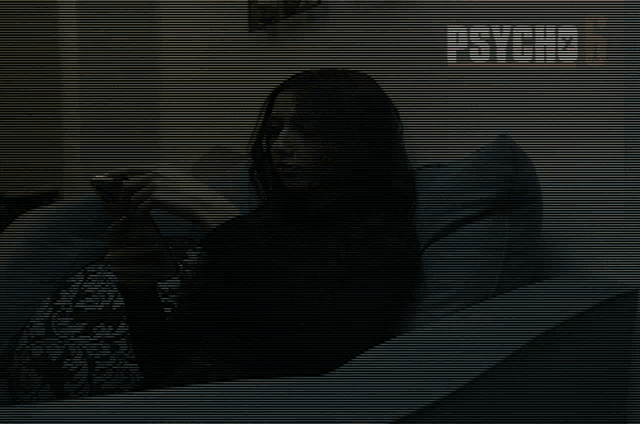 a woman sitting on a couch looking at her phone with a psycho 6 logo behind her