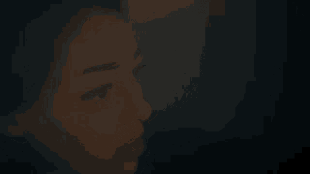 a woman 's face is shown in a dark room