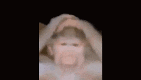 a blurry picture of a person holding their head in the dark .