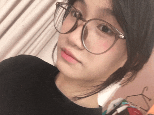 a girl wearing glasses and a black shirt