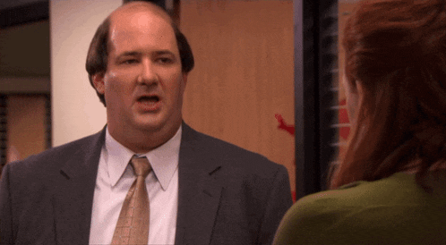 a man in a suit and tie talks to a woman
