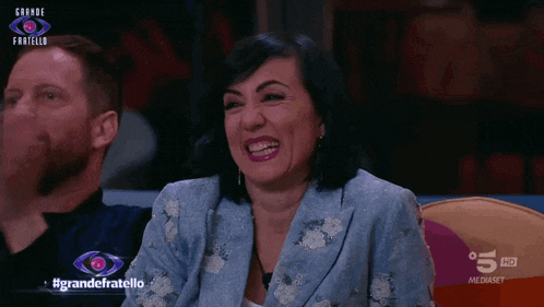 a woman making a funny face with the words grande fratello on the bottom