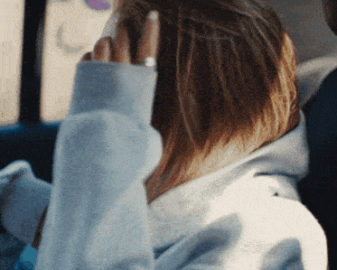 a woman with a ring on her finger is covering her ears in a car