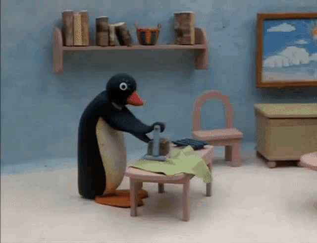a penguin is ironing a piece of cloth on a table in a room