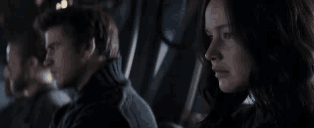 a man and woman are sitting next to each other in a dark room .