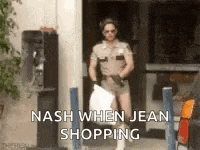 a man in a sheriff 's uniform is carrying a bag and says nash when jean shopping .