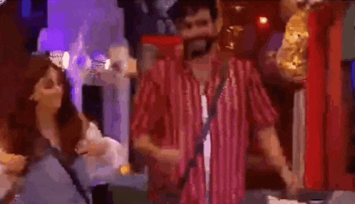 a man and a woman are dancing in a room with a lot of lights .