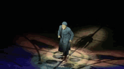 a man in a hat is dancing on a stage