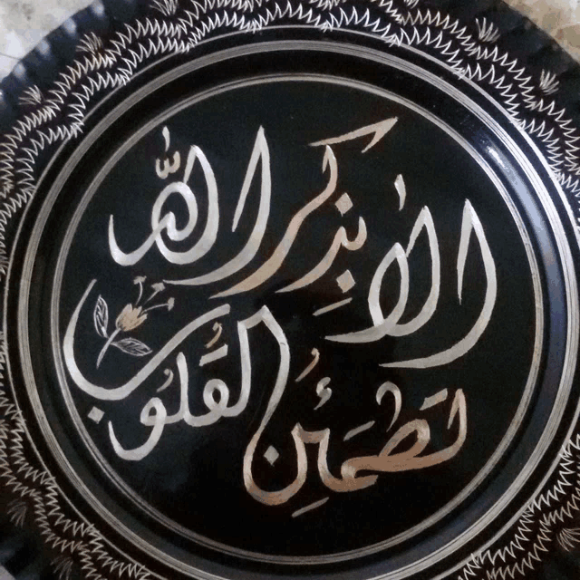 a black circle with arabic writing on it