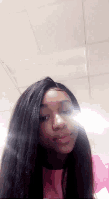 a girl with long hair is taking a picture of herself in the mirror .