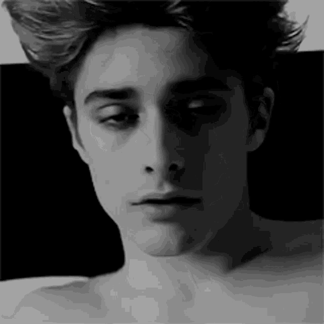 it is a black and white photo of a young man without a shirt .