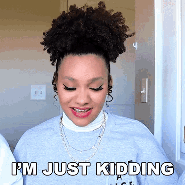 a woman says i 'm just kidding in a gray shirt