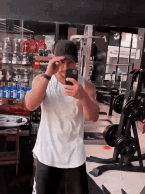 a man is taking a picture of himself in a gym mirror