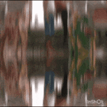 a blurry picture of a person 's face and a reflection of a person in a mirror .