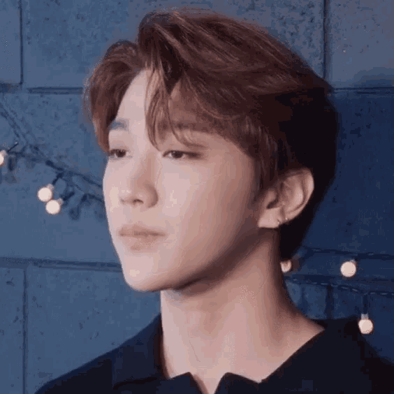 a close up of a young man 's face with lights in the background