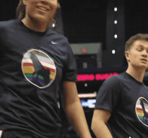 a woman wearing a nike shirt with a picture of a rainbow on it