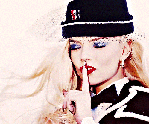 a woman wearing a black hat with the letter s on it
