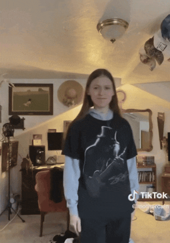 a girl wearing a black shirt with a picture of a man with a top hat on it