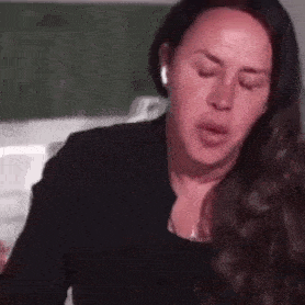 a woman with long hair is wearing headphones and making a face .