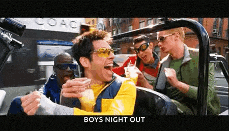 a group of men are sitting in a car and one of them is holding a drink .