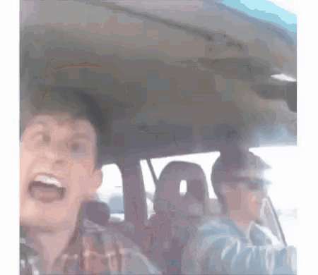 a man is screaming while driving a car with two other people in the back seat .