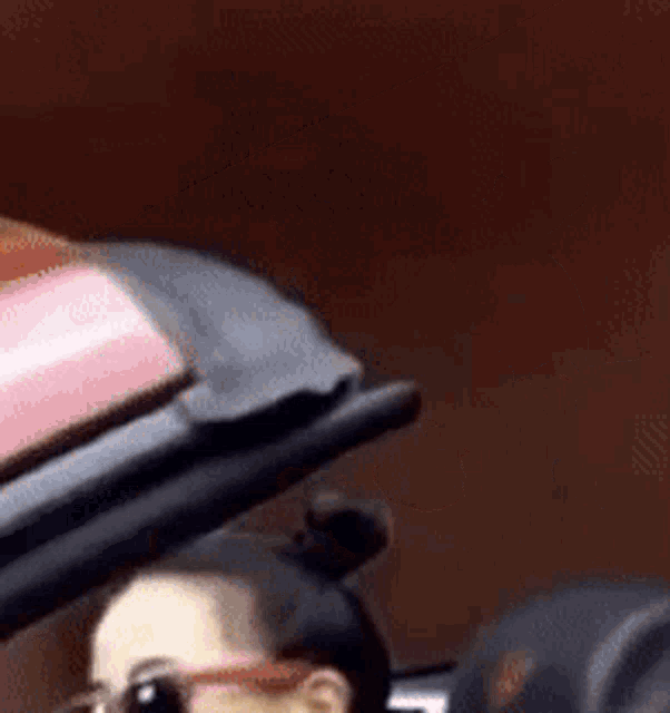 a woman wearing sunglasses is sitting in a convertible car with the roof up .