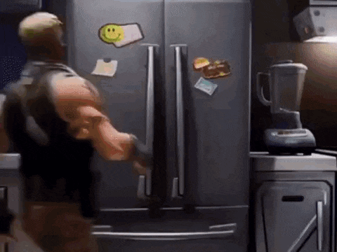a man is opening a refrigerator door in a kitchen .
