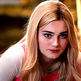 a woman with blonde hair is wearing a pink shirt